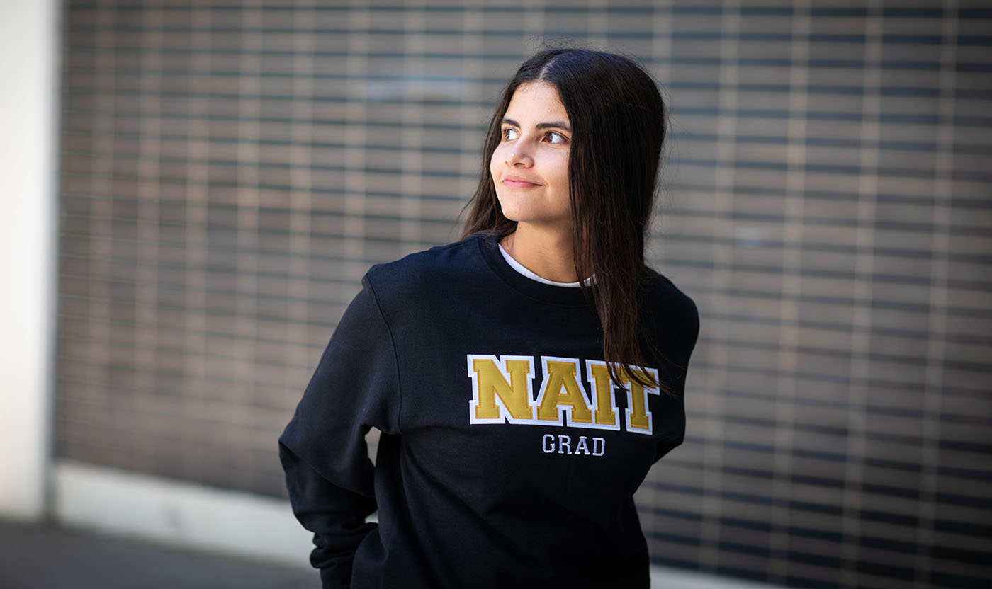 Student wearing a NAIT Grad sweater.