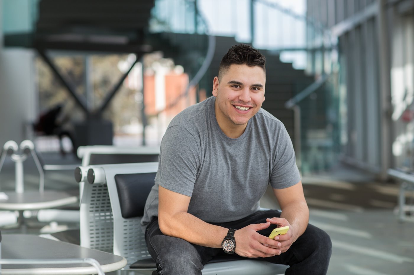 Student sitting in the lobby of the east entrance of building E