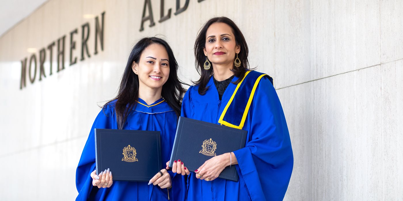 NAIT grads holding their parchment holders at Convocation.