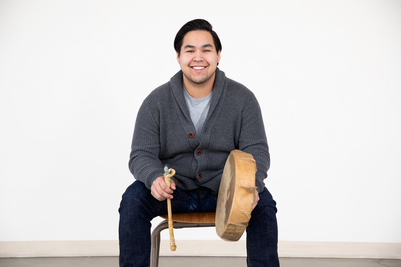 Student sitting on chair with traditional drum